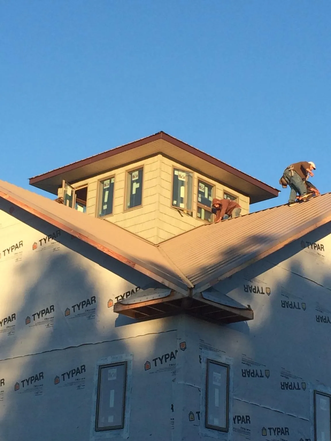 Roofers working around a rooftop cupola on a new metal roof at sunset — Roof Waterproofing in Flemington by Roofing Brothers